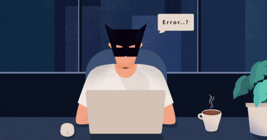 A guy in a mask like a Batman sitting in front of laptop finding an error